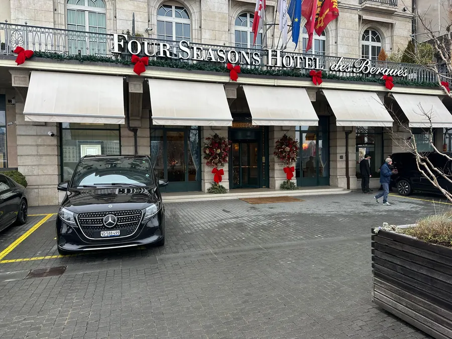 Mercedes V-Class noir de Taxi Eduard devant un grand hôtel à Genève